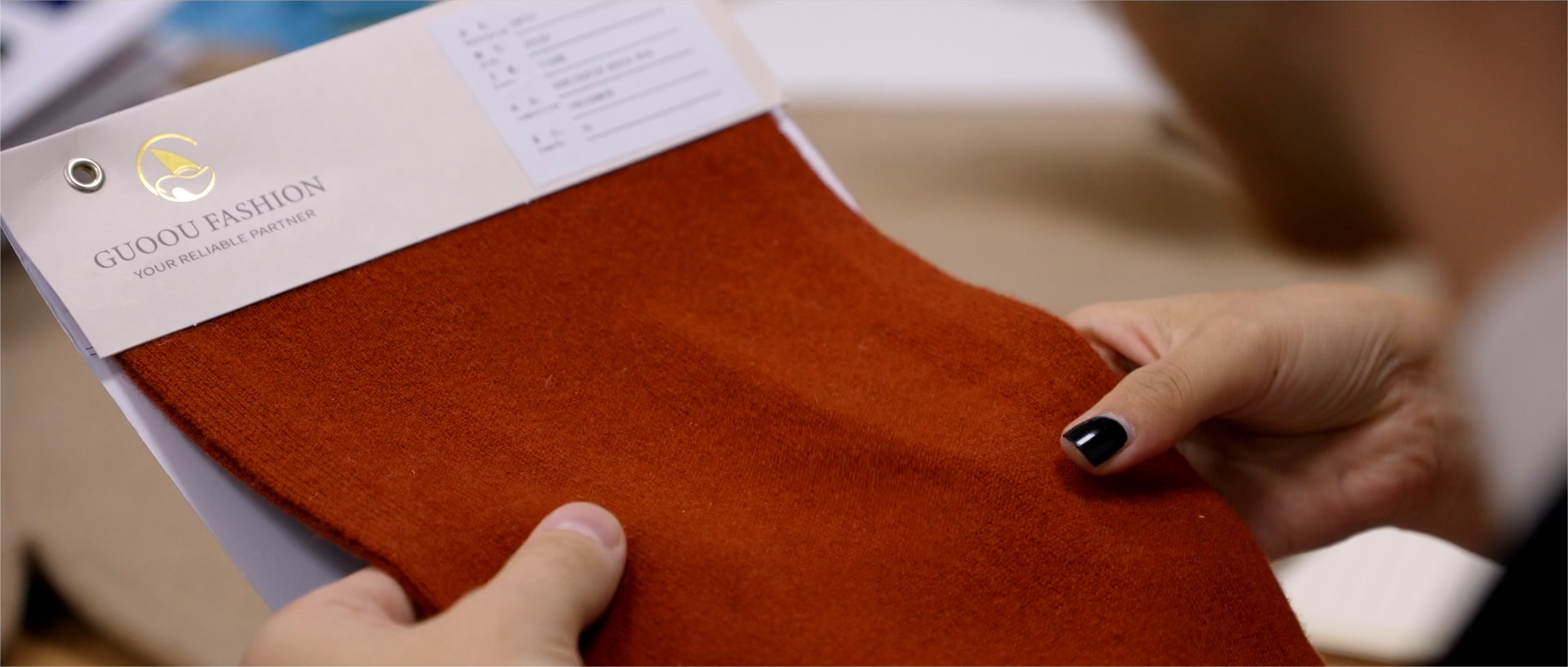 A man is touching the cashmere swatches