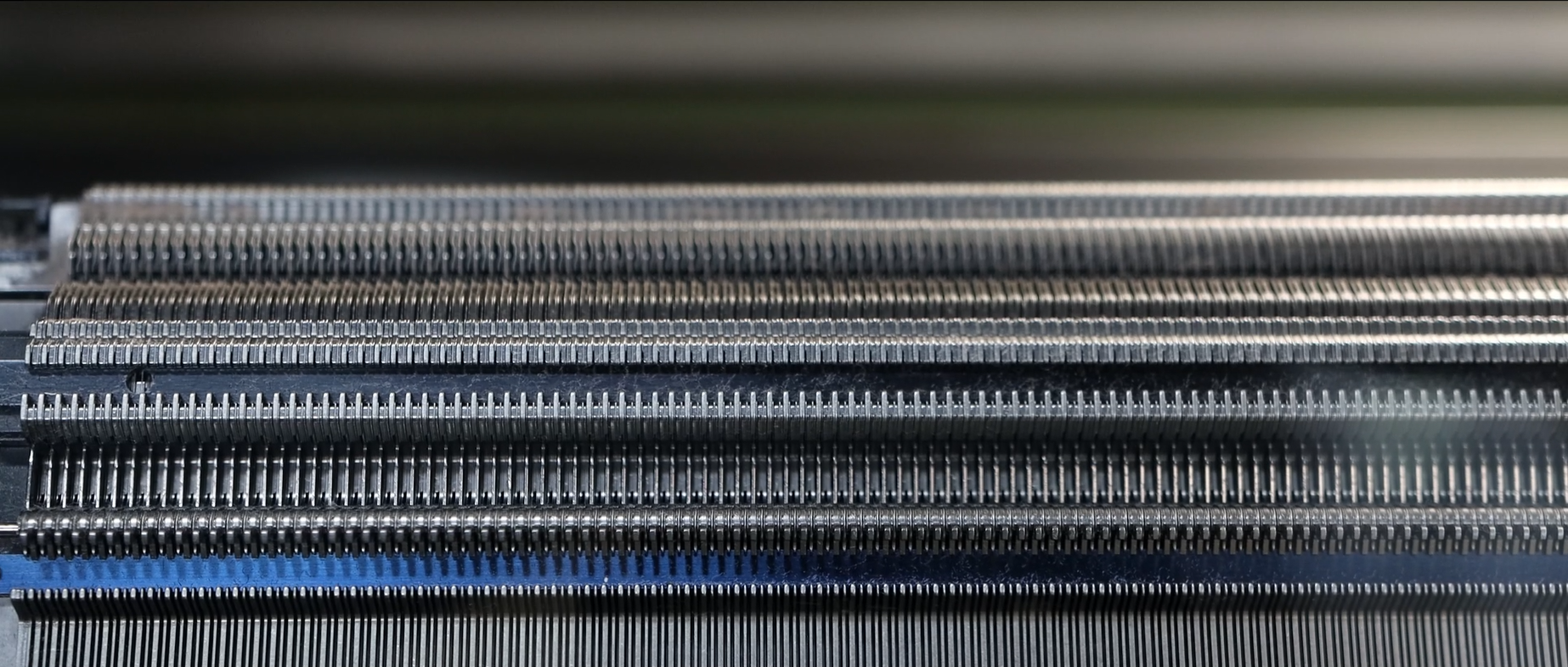 Close-up of the needles of a flat knitting machine